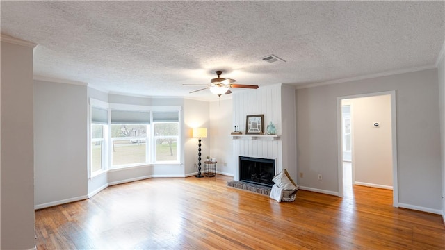 1002 Edgewood Dr, Bryan, TX 77802 - unfurnished living room with ornamental molding, a large fireplace, wood finished floors, ceiling fan, and baseboards
