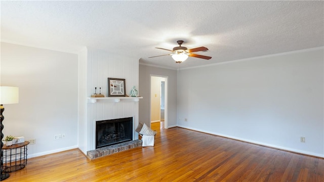 1002 Edgewood Dr, Bryan, TX 77802 - unfurnished living room with wood finished floors, a fireplace, ceiling fan, baseboards, and crown molding