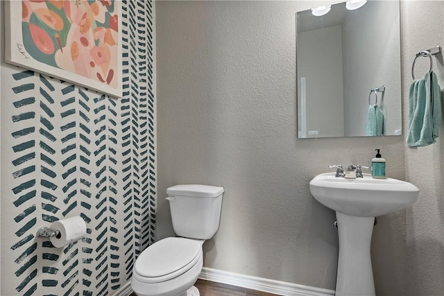 bathroom featuring wood-type flooring and toilet