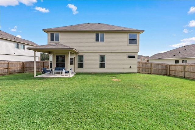 back of property with a yard and a patio