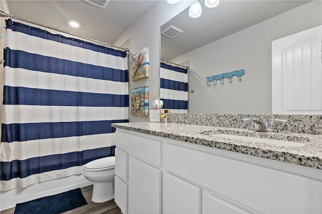 bathroom with wood-type flooring, vanity, and toilet