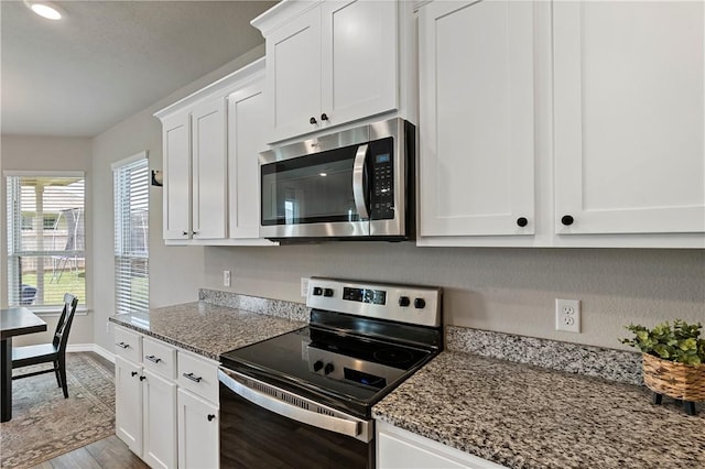 kitchen featuring light stone countertops, stainless steel appliances, white cabinetry, and light hardwood / wood-style flooring