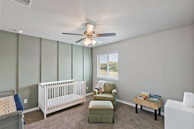 bedroom with carpet flooring, ceiling fan, and a crib