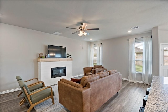 living room featuring ceiling fan and dark hardwood / wood-style flooring