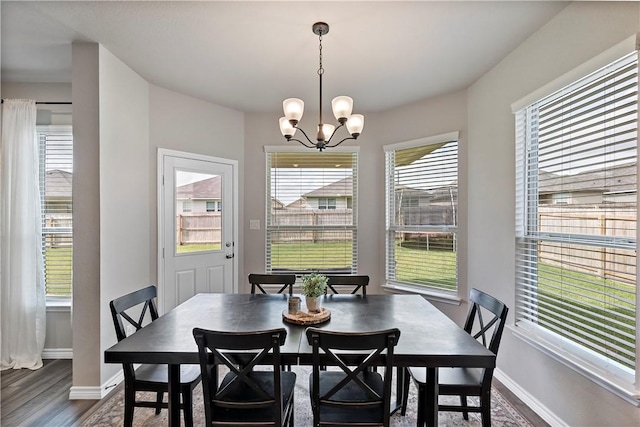 dining room featuring dark hardwood / wood-style floors and an inviting chandelier