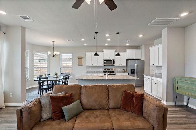 living room featuring sink, ceiling fan with notable chandelier, and hardwood / wood-style flooring