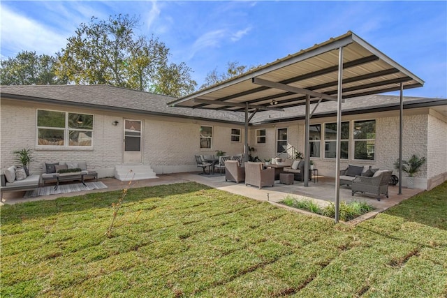 rear view of house with a lawn, outdoor lounge area, and a patio area