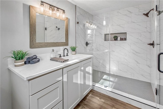 bathroom with vanity, wood-type flooring, and an enclosed shower