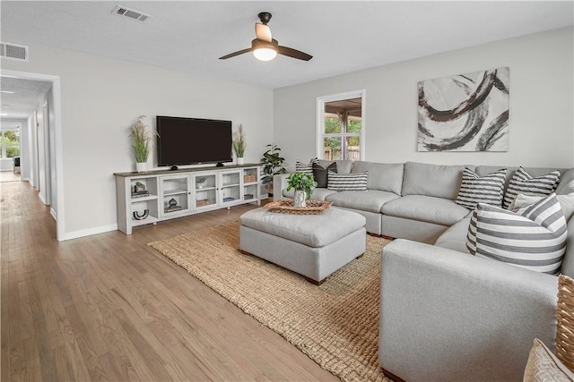 living room featuring hardwood / wood-style floors and ceiling fan