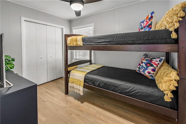 bedroom with ceiling fan, light hardwood / wood-style floors, crown molding, and a closet