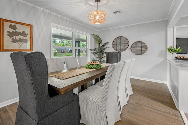 dining area featuring hardwood / wood-style flooring and crown molding