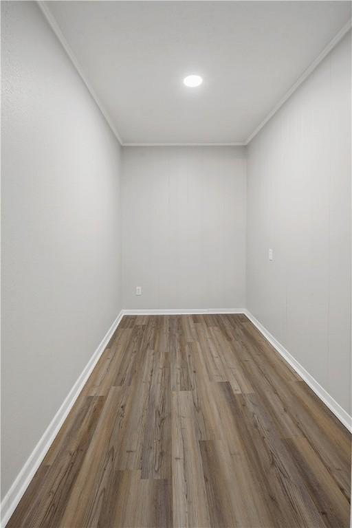 empty room with wood-type flooring and ornamental molding