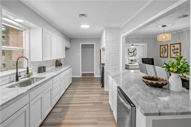 kitchen featuring white cabinets, light hardwood / wood-style floors, light stone counters, and sink