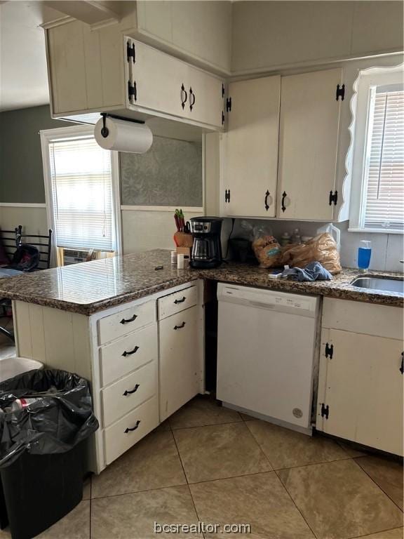 kitchen with white cabinets, dishwasher, light tile patterned floors, and sink