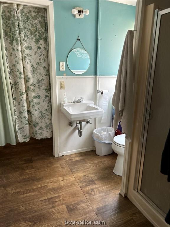 bathroom featuring sink, toilet, wood-type flooring, and walk in shower