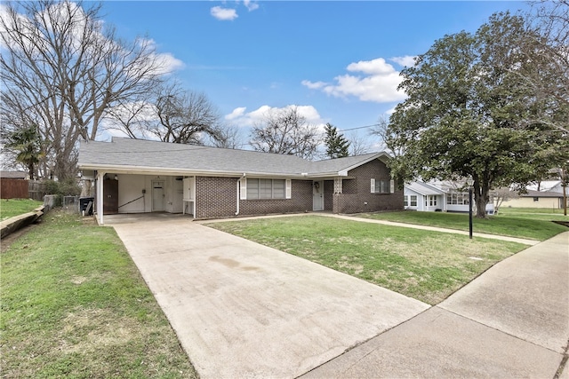 ranch-style house featuring an attached carport, brick siding, driveway, and a front lawn