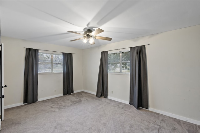 unfurnished room featuring light carpet, ceiling fan, and baseboards