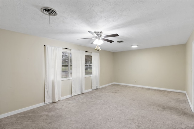 unfurnished room with light colored carpet, visible vents, ceiling fan, and baseboards