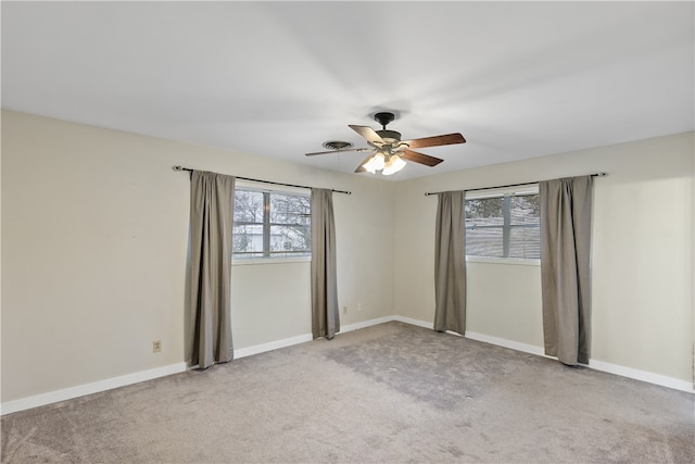 carpeted empty room featuring ceiling fan and baseboards