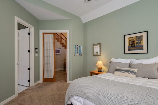 bedroom with light colored carpet and vaulted ceiling