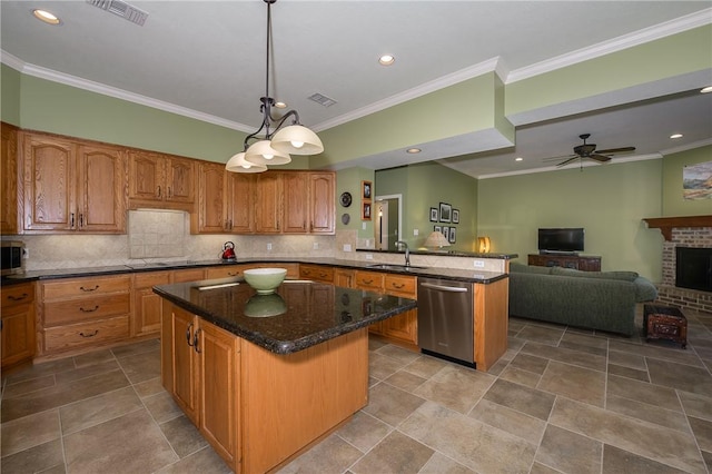 kitchen with a brick fireplace, stainless steel appliances, sink, a kitchen island, and hanging light fixtures