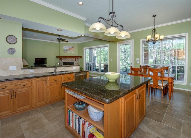 kitchen featuring dark stone countertops, sink, hanging light fixtures, and ceiling fan with notable chandelier