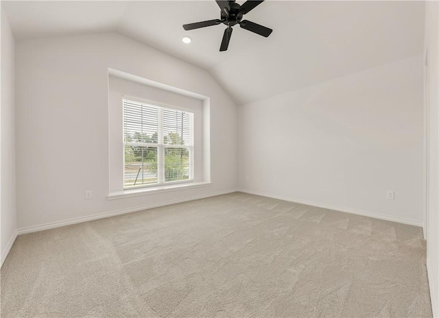 carpeted spare room with ceiling fan and vaulted ceiling