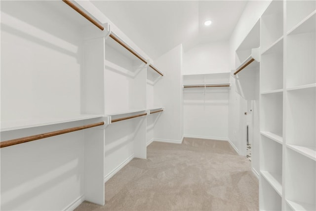 walk in closet featuring light carpet and vaulted ceiling