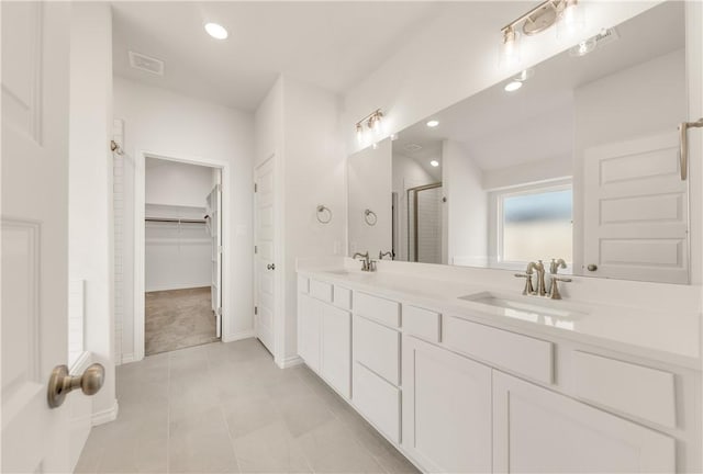 bathroom featuring tile patterned flooring, vanity, and a shower with shower door