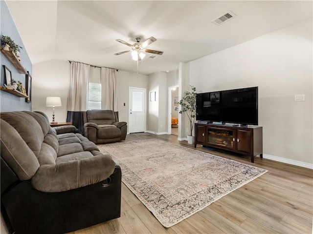 living room featuring hardwood / wood-style flooring, ceiling fan, and vaulted ceiling