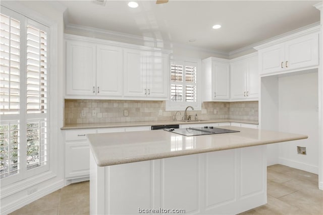 kitchen with white cabinets, a center island, and a healthy amount of sunlight