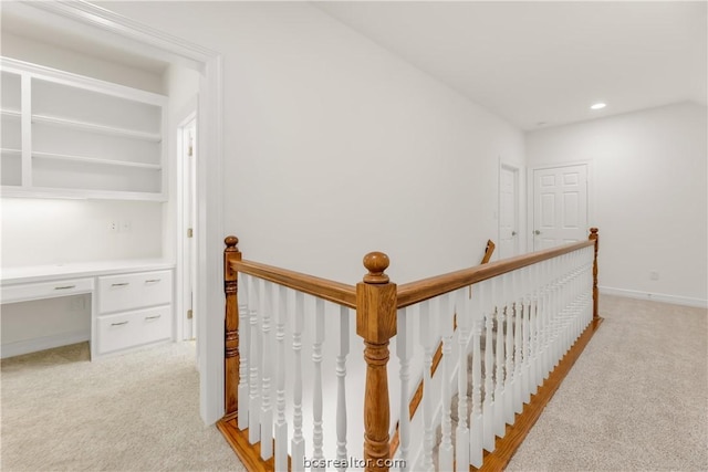 hall with light colored carpet