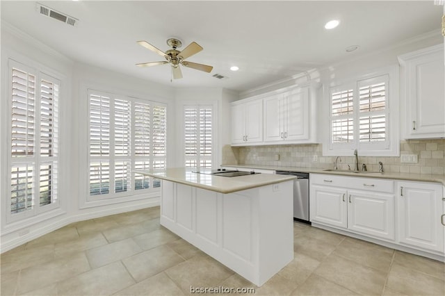 kitchen featuring a center island, white cabinets, sink, stainless steel dishwasher, and tasteful backsplash