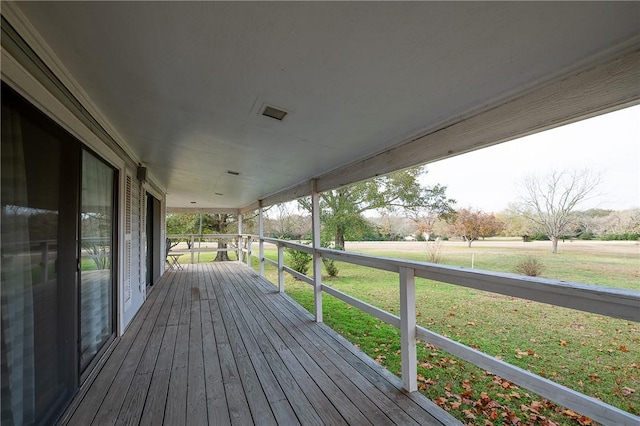 wooden deck featuring a porch and a yard