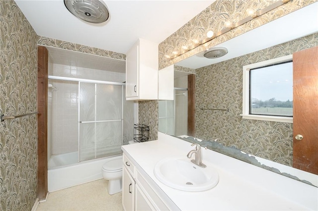 full bathroom with combined bath / shower with glass door, vanity, and toilet