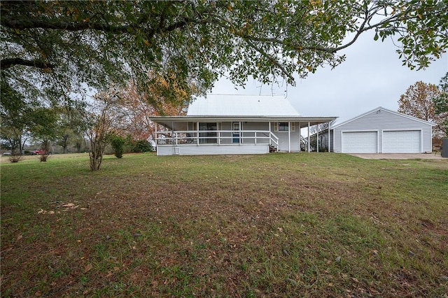 view of front of home with a sunroom, an outbuilding, a front lawn, and a garage