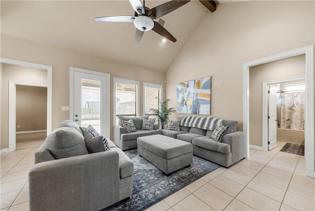 living area featuring light tile patterned floors, ceiling fan, high vaulted ceiling, beamed ceiling, and baseboards