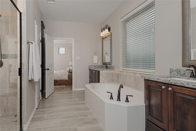 bathroom with vanity and shower with separate bathtub