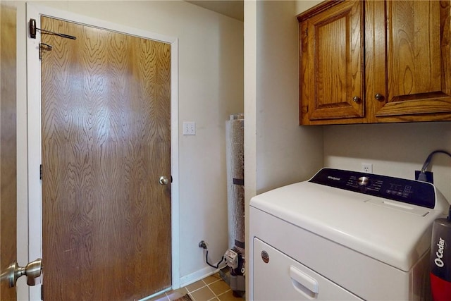 clothes washing area with tile patterned floors, cabinet space, and washer / dryer