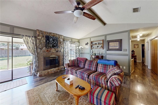 living area featuring lofted ceiling with beams, wood finished floors, visible vents, and ceiling fan