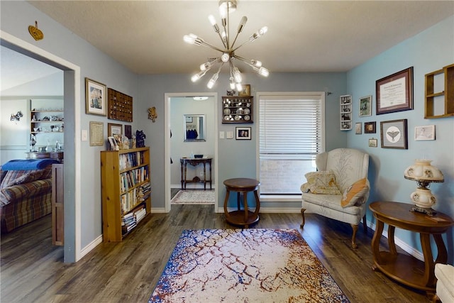 living area with a notable chandelier, wood finished floors, and baseboards