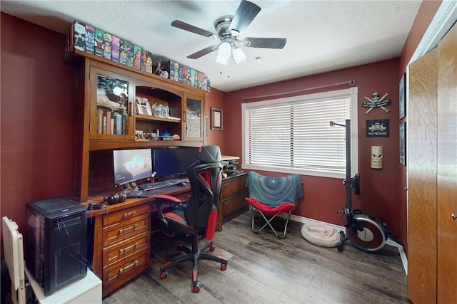 office area with baseboards, wood finished floors, and a ceiling fan