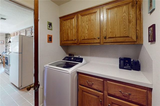 laundry room featuring visible vents, cabinet space, and washer / clothes dryer