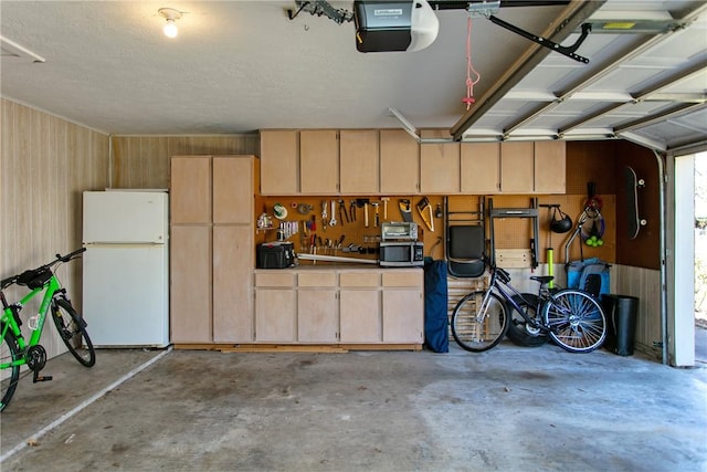 garage featuring a garage door opener and freestanding refrigerator