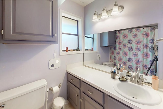 bathroom featuring a shower with shower curtain, toilet, and vanity