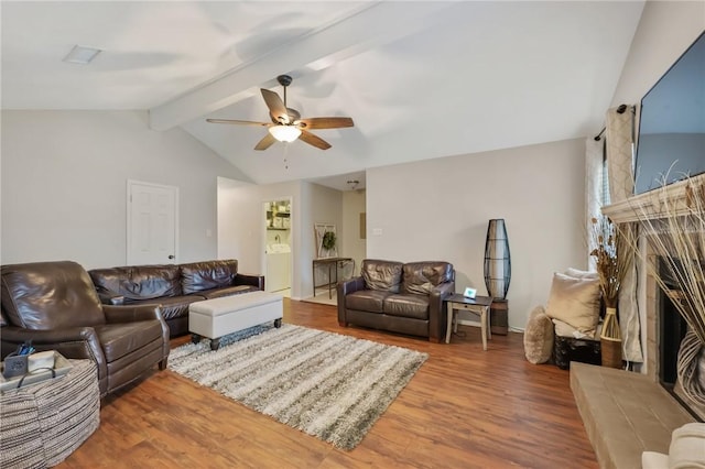 living room featuring ceiling fan, vaulted ceiling with beams, wood-type flooring, and washer / dryer