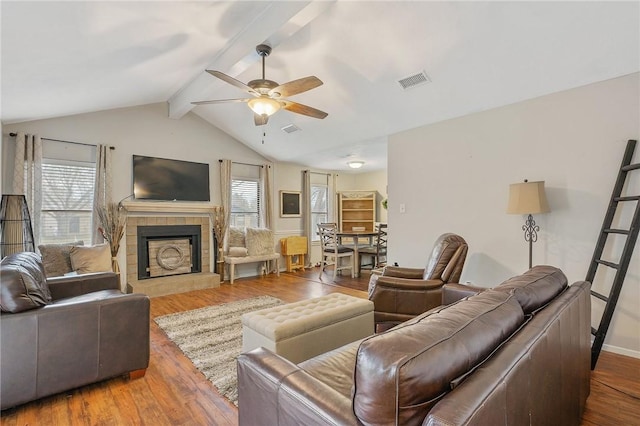 living room with vaulted ceiling with beams, a fireplace, hardwood / wood-style flooring, and ceiling fan