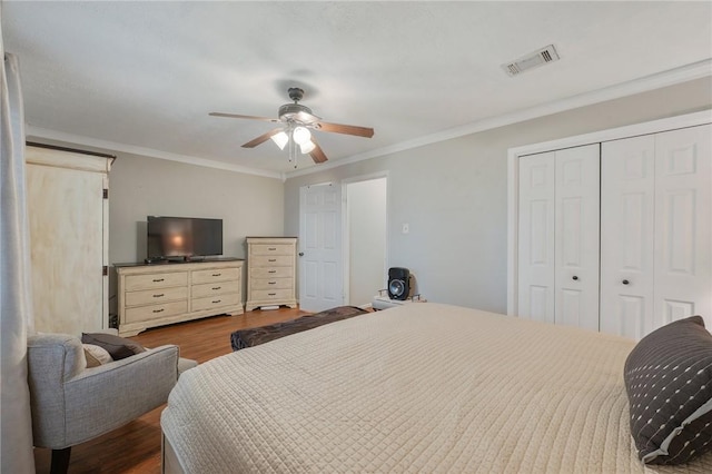 bedroom with ceiling fan, ornamental molding, a closet, and hardwood / wood-style flooring