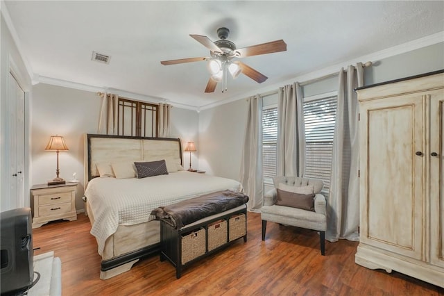 bedroom with ceiling fan, ornamental molding, and hardwood / wood-style floors