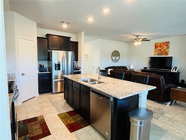 kitchen with sink, ceiling fan, an island with sink, appliances with stainless steel finishes, and dark brown cabinets